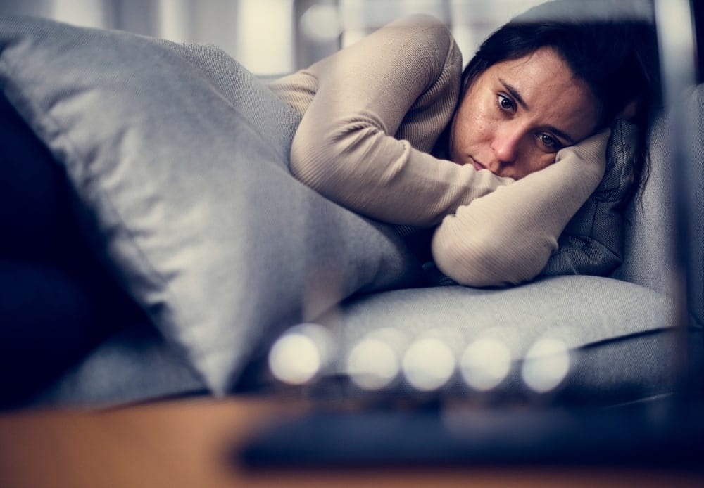depressed woman lying in bed