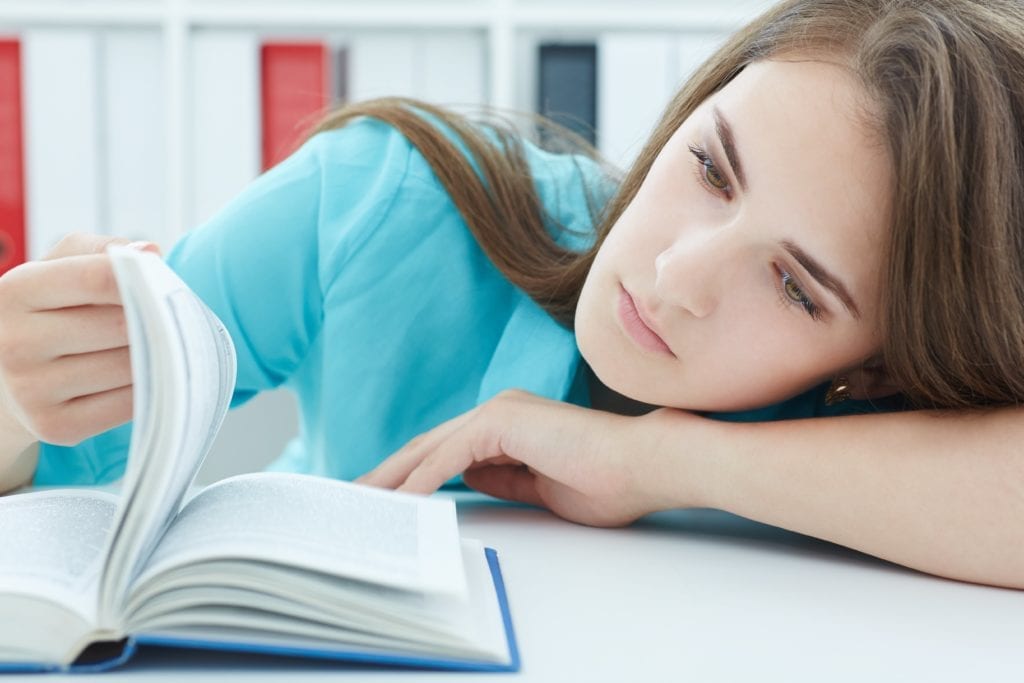 depressed woman trying to read a book