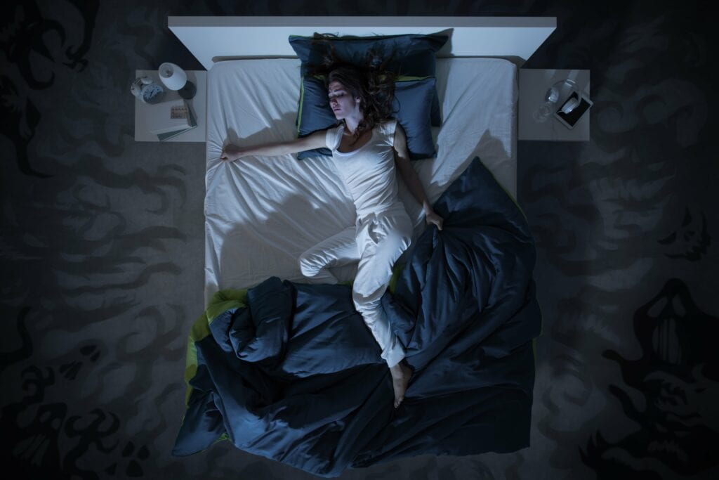 woman restlessly sleeping in bed