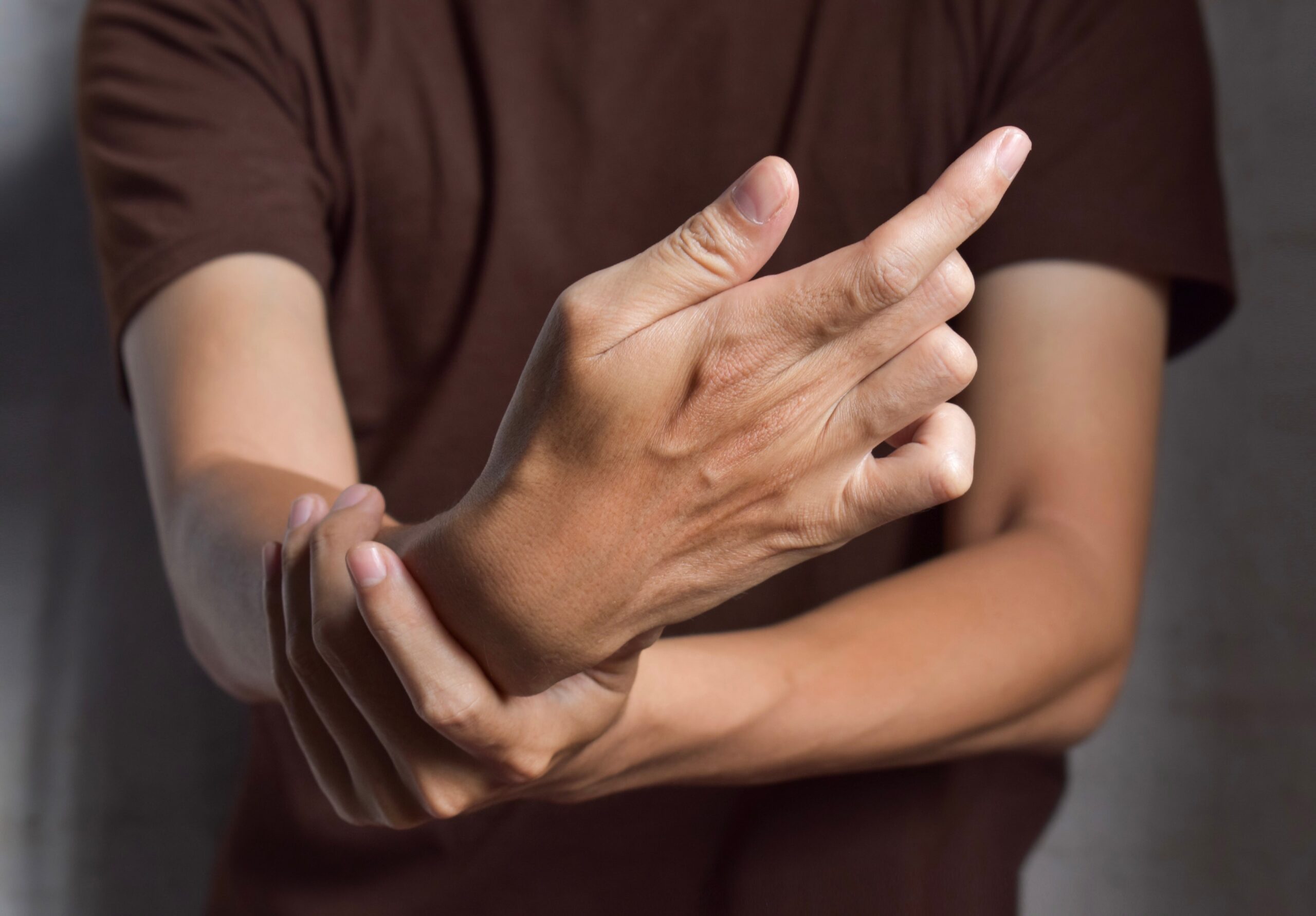 Fingers rigidity, Hand muscles spasm, or Weakness of digits. Closeup view.
