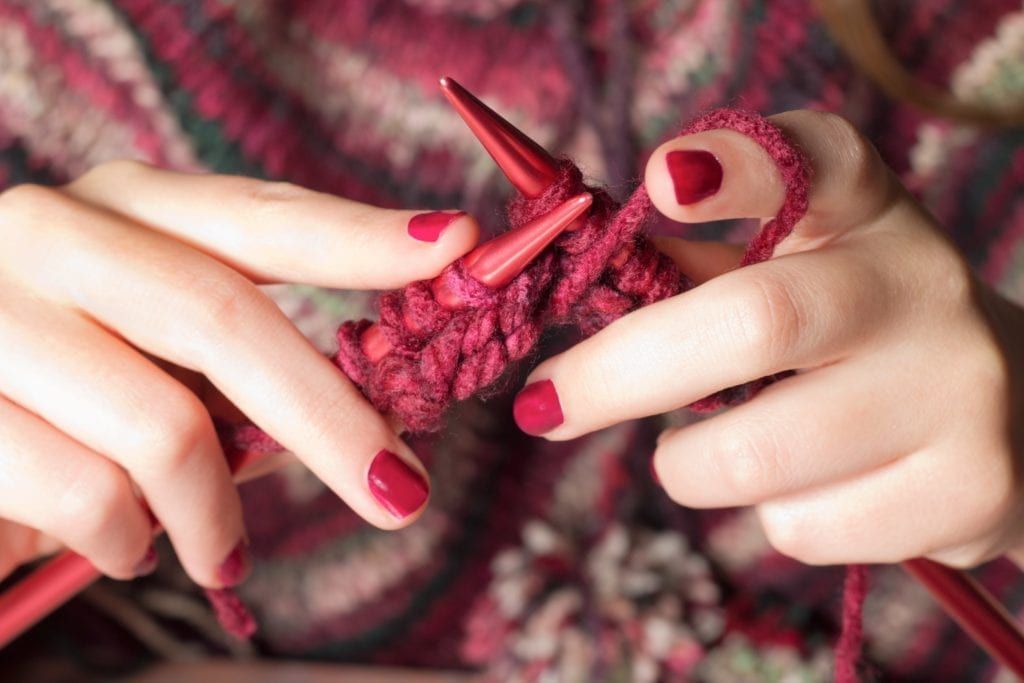 Closeup of two hands knitting