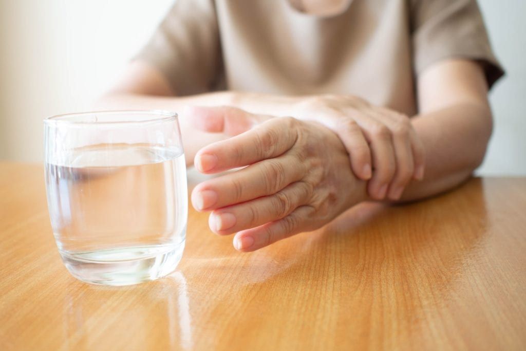 shaky hand reaching for a glass of water
