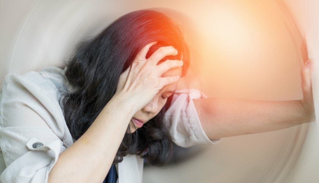 woman clutching her head in pain