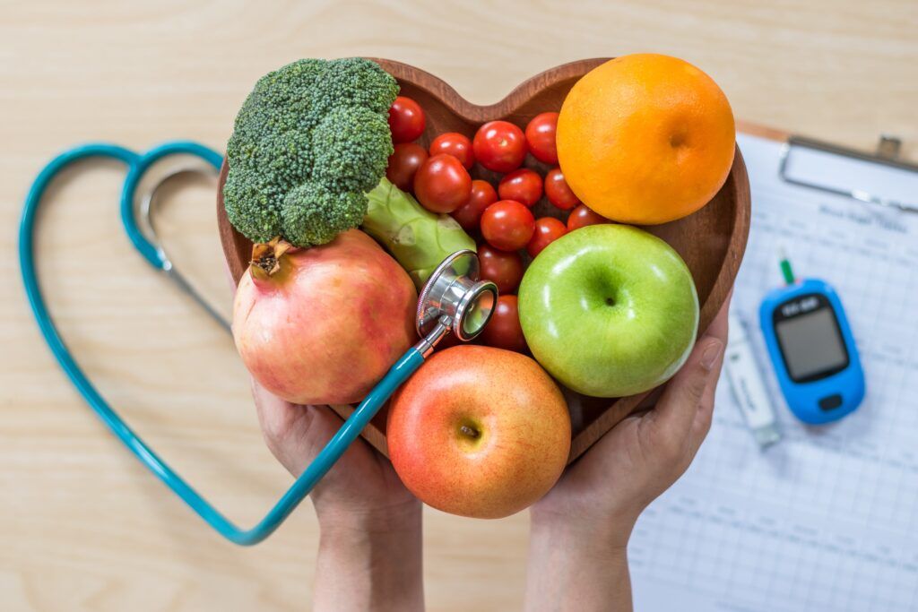 healthy food next to stethoscope and blood sugar monitor