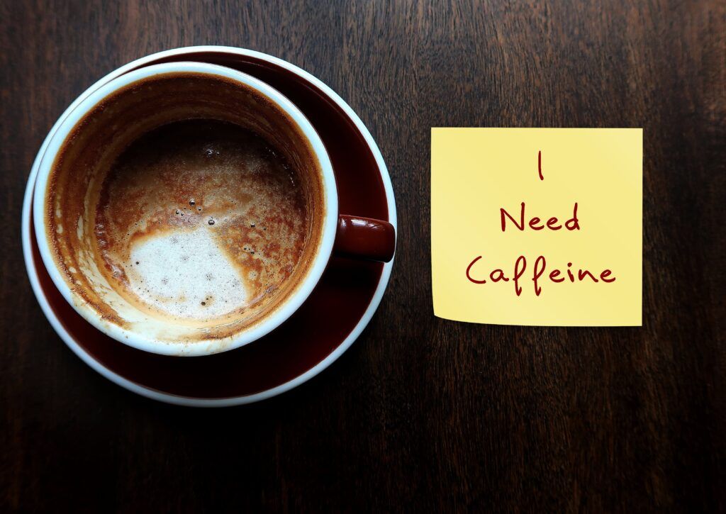 empty coffee mug with a post it note reading, "I need caffeine"